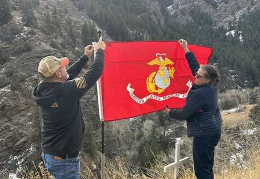 Marine Corps veteran Elliot Pappas and Conifer resident Dawn Borg erect a new flag at the site where veteran Albert Lujan died on U.S. 285 near Highway 8.